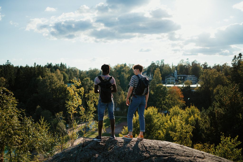 Kaksi nuorta miestä seisomassa kallion päällä